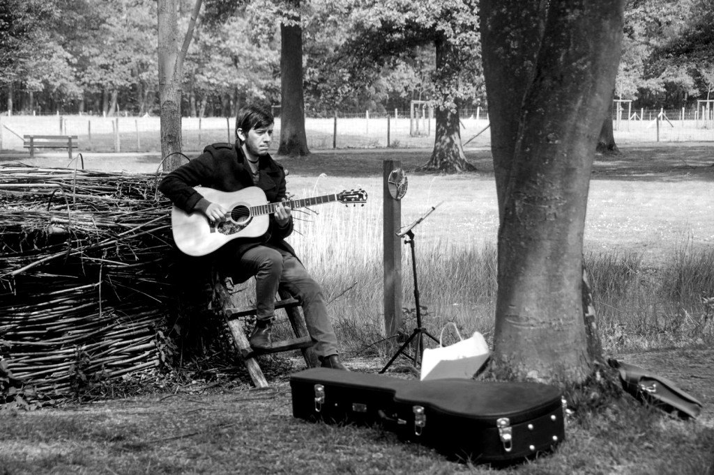 Portret van Stijn, de ervaren gitaarleraar van StudiOSB in Geraardsbergen.